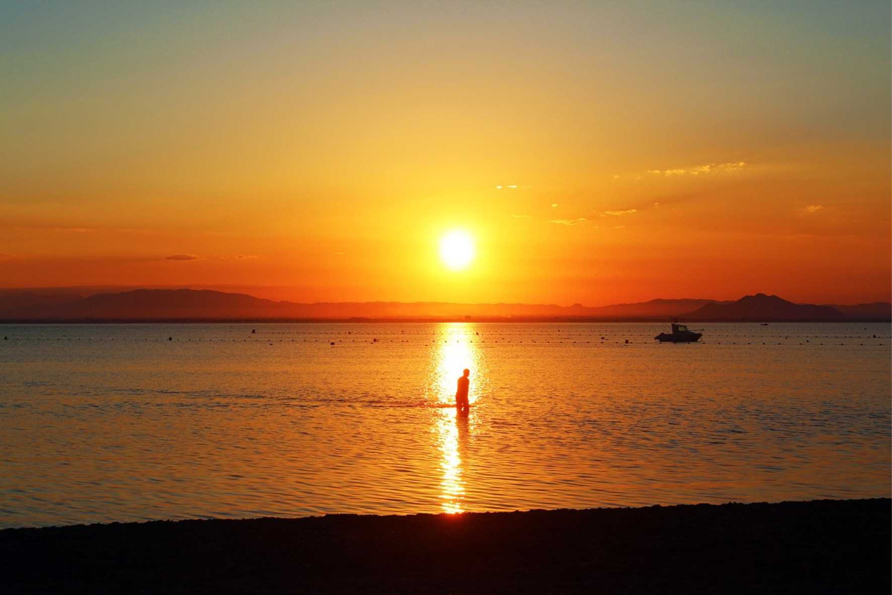puesta de sol en playa con persona
