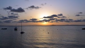 puesta de sol en el mar con embarcaciones